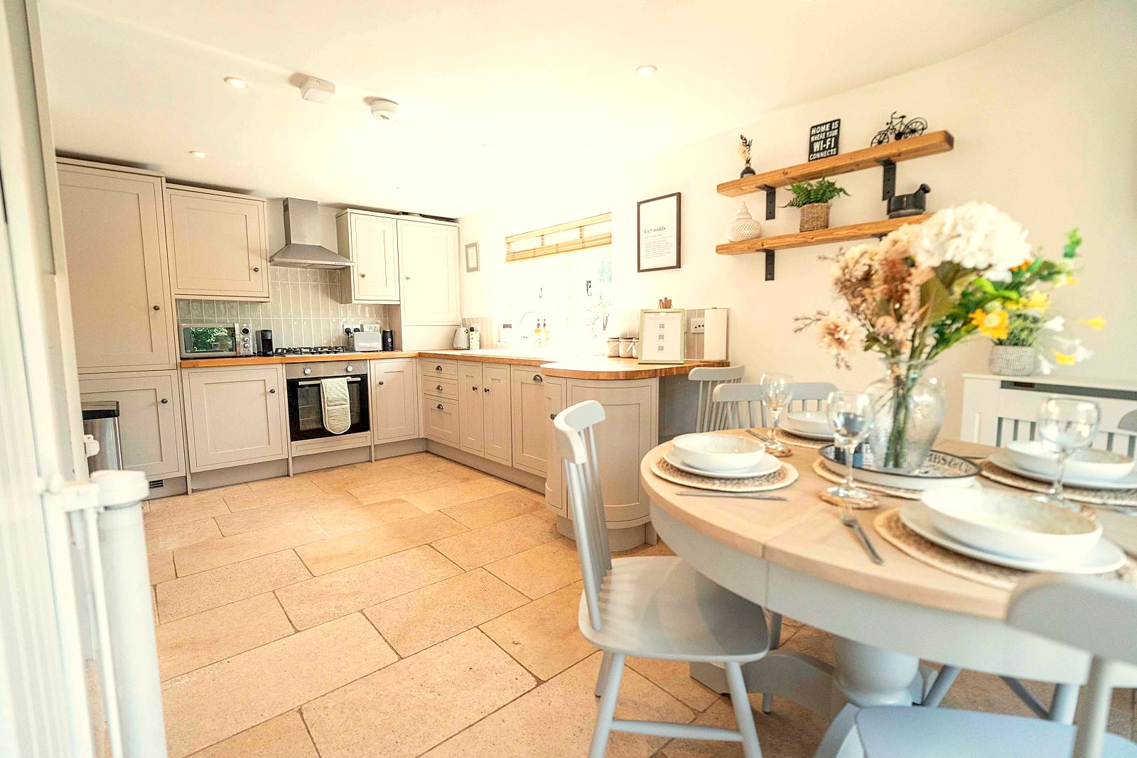 Kitchen and round dining table laid for guests